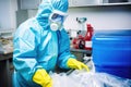 lab technician disposing waste in biohazard container