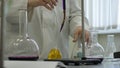 Lab technician doing experiment in lab. Male medical or scientific laboratory researcher performs tests with blue liquid Royalty Free Stock Photo