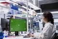 Lab technician looking at 3D molecular model on green screen computer Royalty Free Stock Photo