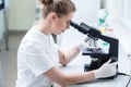 Lab technician looking through microscope