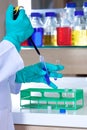 Lab technician wearing gloves using a pipette