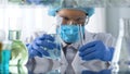 Lab worker examining test tube with liquid before mixing reagents, internship