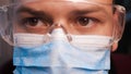 A lab worker in a mask puts on protective work glasses for working in laboratories. Concept of: Protective mask, Protective goggle Royalty Free Stock Photo