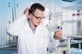 Lab worker in observing test tube with mold at the laboratory