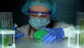 Lab worker opening Petri dish with green powder, cosmological production