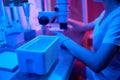 Lab worker performs an ICSI procedure under a powerful microscope