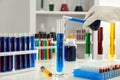 Lab worker pouring blue liquid into test tube on table Royalty Free Stock Photo