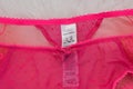 Label M&S on lacy pink panties on white fur. Close up. Fashionable concept of lingerie Royalty Free Stock Photo