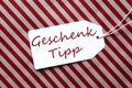 Label On Red Wrapping Paper, Geschenk Tipp Means Gift Tip Royalty Free Stock Photo