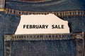 Label with text february sale in the pocket of blue denim jeans.