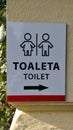 Label on the wall showing direction to the toilet written both in Czech and English