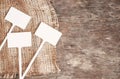 Labels-markers for plants lie on burlap, on a wooden brown background., Top view