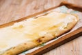 Labneh with asal pizza bread served in wooden board on background top view of Arabic Manaqeesh