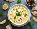 Labneh cream cheese dip with olive oil, salt, herbs served with olives, pita bread in white bowl