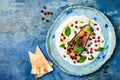 Labneh middle eastern lebanese cream cheese dip with roasted aubergine, pomegranate, mint and pita.