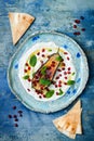 Labneh middle eastern lebanese cream cheese dip with roasted aubergine, pomegranate, mint and pita.