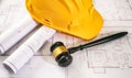 Labor, Construction law. Safety helmet and judge gavel on building blueprint, overhead