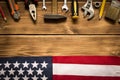 Labor day. American flag and various tools on a wooden background. The concept of labor day. Empty space for text Royalty Free Stock Photo