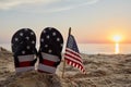 Labor Day USA background with with flip flops on the sandy beach. Patriotic USA background Royalty Free Stock Photo