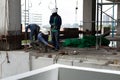 Labor man working on construction site with helmet pulling concrete slabs using pulley