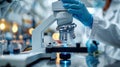Laboratory assistant conducts microscopic analysis using a modern microscope in a white lab Royalty Free Stock Photo