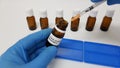 Laboratory assistant filling the syringe with Covid-19 vaccine from a vial