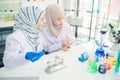 Laboratory assistant filling test-tube with blood sample while doctor making notes