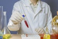 The laboratory assistant holds a flask in his hand. Chemical formulation for medicine, laboratory research.