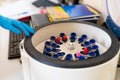 The laboratory assistant places a test tube with a sample for analysis into a centrifuge apparatus, close-up Royalty Free Stock Photo