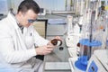 Laboratory assistant pours liquid from a bottle