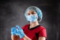 Laboratory assistant in red uniform looking at blood samples at test tube isolated on black Royalty Free Stock Photo