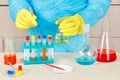 Laboratory assistant in rubber gloves is conducting chemical experiments in laboratory