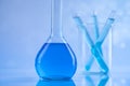 Laboratory beakers, microscope, blue background Royalty Free Stock Photo