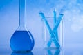 Laboratory beakers, microscope, blue background Royalty Free Stock Photo
