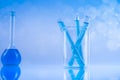Laboratory beakers, microscope, blue background Royalty Free Stock Photo