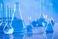 Laboratory beakers, microscope, blue background Royalty Free Stock Photo