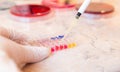 Laboratory doctor or scientific researcher using a pipette to take samples of infected urine