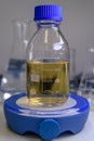 A laboratory glass bottle filled with yellow liquid for coronavirus research