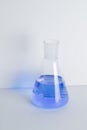 Laboratory glass Erlenmeyer conical flask filled with blue chemical liquid for a chemistry experiment in a science Royalty Free Stock Photo