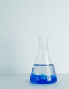 Laboratory glass Erlenmeyer conical flask filled with blue chemical liquid for a chemistry experiment in a science Royalty Free Stock Photo