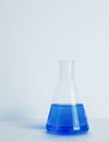 Laboratory glass Erlenmeyer conical flask filled with blue chemical liquid for a chemistry experiment in a science Royalty Free Stock Photo