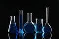 Laboratory glassware with blue liquids on background