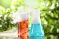 Laboratory glassware with colorful liquids on glass table outdoors. Chemical reaction Royalty Free Stock Photo