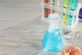 Laboratory glassware with colorful liquids and steam on white wooden table, space for text. Chemical reaction Royalty Free Stock Photo