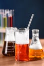 Laboratory glassware with colorful liquids on wooden table, closeup. Chemical reaction Royalty Free Stock Photo