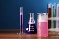 Laboratory glassware with colorful liquids on wooden table, space for text. Chemical reaction Royalty Free Stock Photo