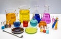 Laboratory glassware with liquids of different colors on white table. Volumetric laboratory glassware over white background Royalty Free Stock Photo