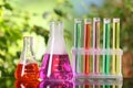 Laboratory glassware and test tubes with liquids on glass table outdoors. Chemical reaction Royalty Free Stock Photo