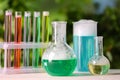 Laboratory glassware and test tubes with colorful liquids on white table outdoors. Chemical reaction Royalty Free Stock Photo