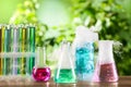 Laboratory glassware and test tubes with colorful liquids on wooden table outdoors. Chemical reaction Royalty Free Stock Photo